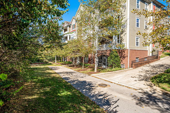Side view of a multi-story residential building with a brick and siding exterior.