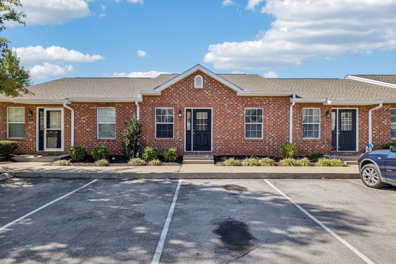 Front view of a single-story brick house with multiple doors and windows.