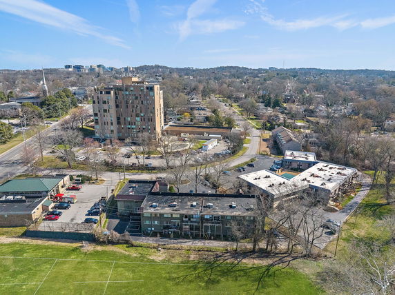 Aerial view of a residential area with multiple buildings, roads, and greenery.