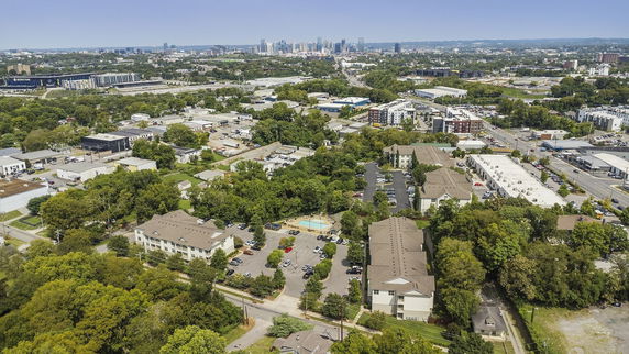 Aerial view of a residential and urban area with buildings, roads, and greenery.