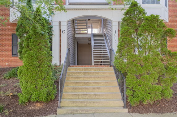 Front view of a building with an entrance staircase and brick facade.