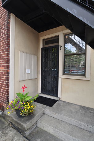 Front view of a doorway with metal gate and stairs leading up to it.