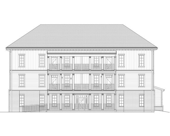 Front view of a multi-story building with balconies and a pitched roof.