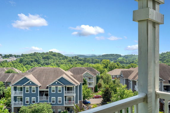 Panoramic view of apartment buildings with hilly landscape in the background.