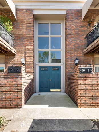 Front view of a building entrance with double doors and large windows above.