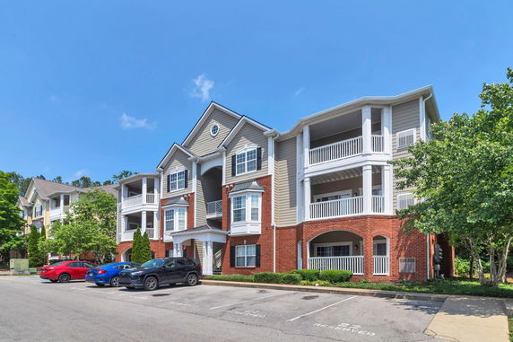 Front view of a multi-story residential building with balconies and brick facade.