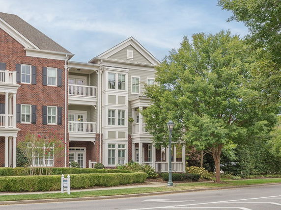 Front view of a multi-story residential building with brick and siding exterior.