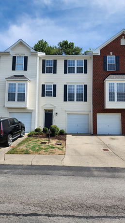 Front view of a three-story townhouse with a garage.