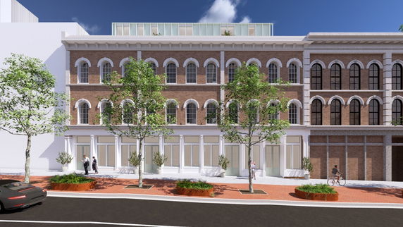 Front view of a three-story brick building with arched windows and modern elements.