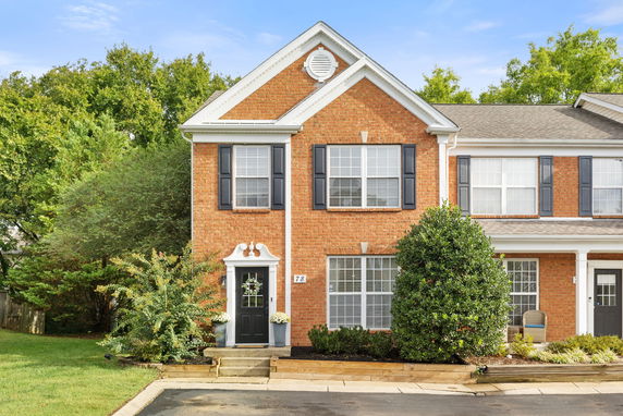 Front view of a two-story brick house with white trim and a gabled roof.