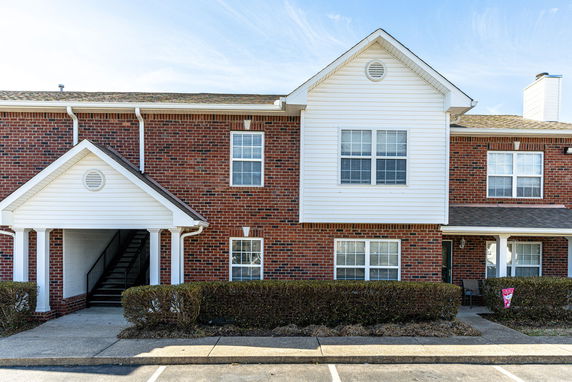 Front view of a brick apartment building with a white trim.