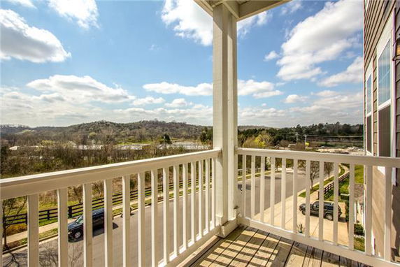 View from a balcony overlooking a scenic landscape with hills and road.