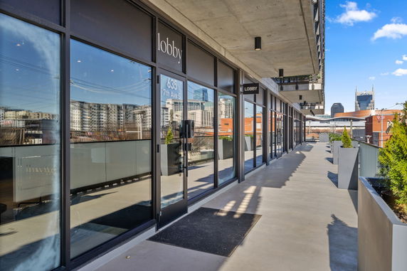 Front view of a building with glass windows and a concrete pathway.