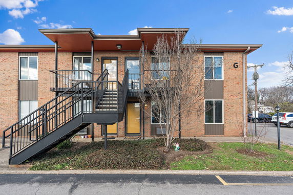 Front view of a two-story apartment building with external staircase.
