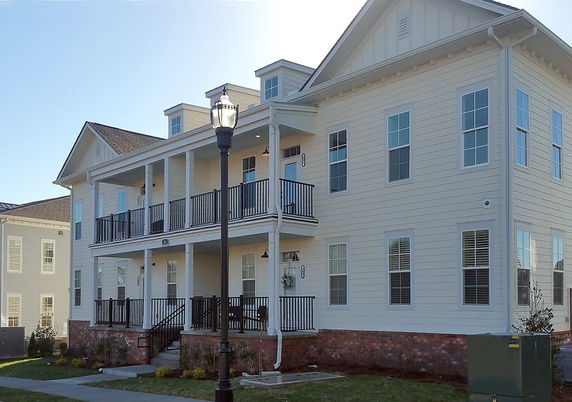 Front view of a two-story house with a covered balcony and multiple windows.