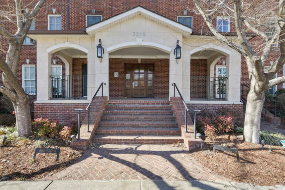 Front view of a brick building with steps leading to the entrance.