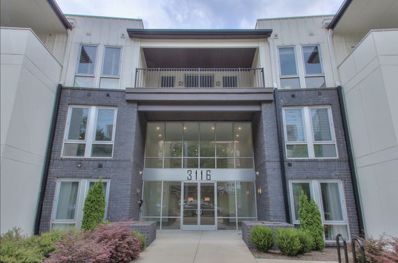 Front view of a multi-story building with large windows and a central entrance.