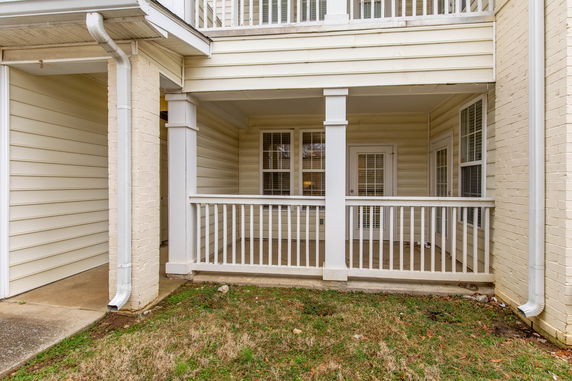 Front view of a house with a small porch and railings.