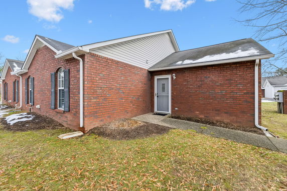 Front view of a single-story brick house with arched windows and a visible front door.