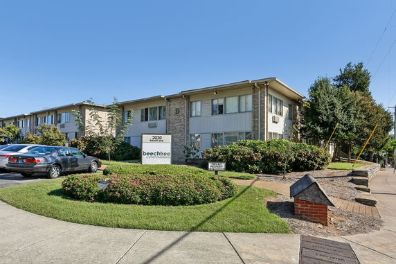 Front view of a two-story condominium building with a sign labeled 'beechtree condominiums'.
