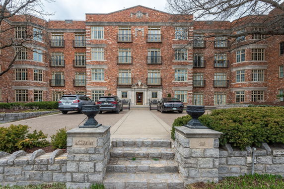 Front view of a multi-story brick building with multiple windows and an entranceway.
