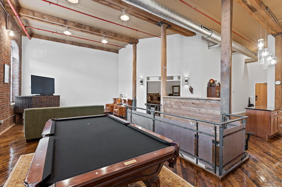 Interior view with exposed beams, pool table, and seating area.