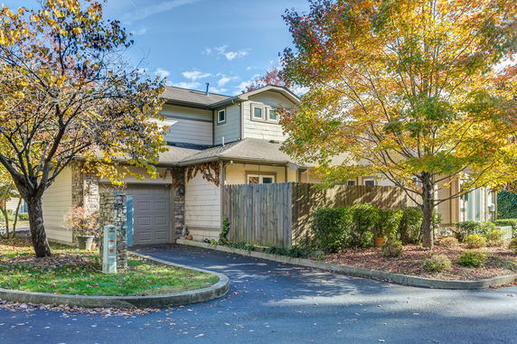 Front view of a two-story house with a garage and fenced yard.
