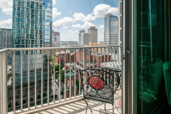 Panoramic view of a cityscape with tall buildings seen from a balcony.