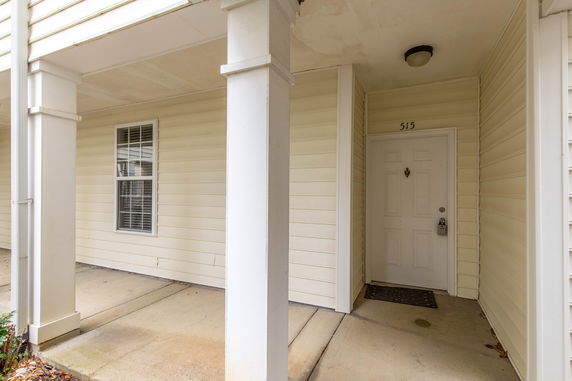 Front view of a house entrance with a covered porch and columns.