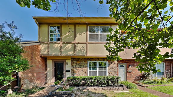 Front view of a two-story house with a mix of brick and stone facade.