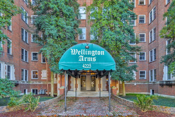 Front view of a multi-story brick building with an entrance canopy.