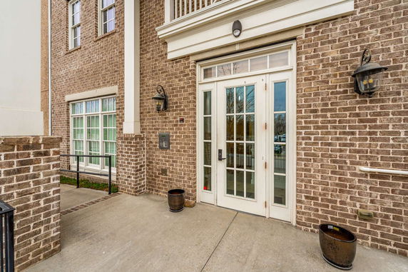 Front view of a building with brick exterior and double glass doors.
