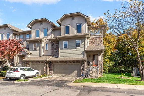 Front view of a multi-story townhouse with attached garage.
