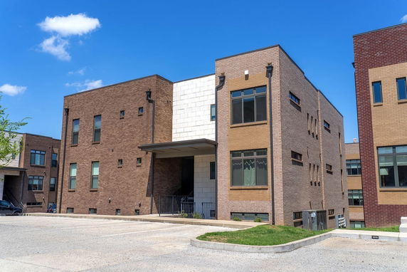 Front view of a modern three-story building with brick facade.