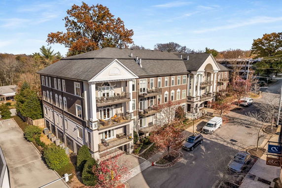 Front view of a multi-story apartment building with balconies and archway entrance.