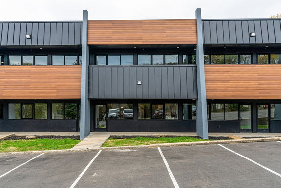 Front view of a contemporary two-story building with wood and metal facade.