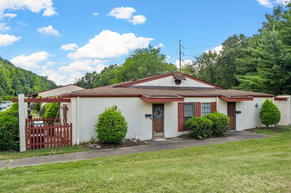 Front view of a single-story house with brown trim and small entrance patio.