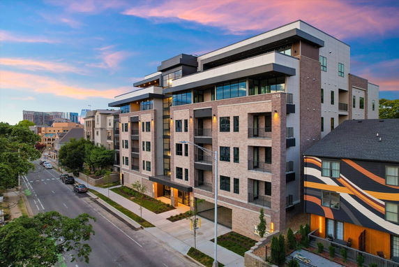 Front view of a modern multi-story apartment building with balconies.