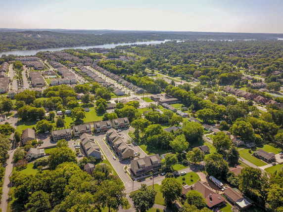 Aerial view of a residential neighborhood with rows of houses and surrounding greenery.