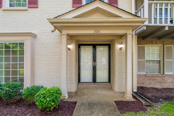 Front view of a house entrance with a double door and decorative molding.