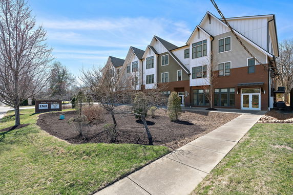Front view of a modern townhouse complex with angled roofs and multiple levels.