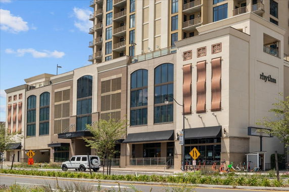 Front view of a mixed-use building with large windows and balconies.