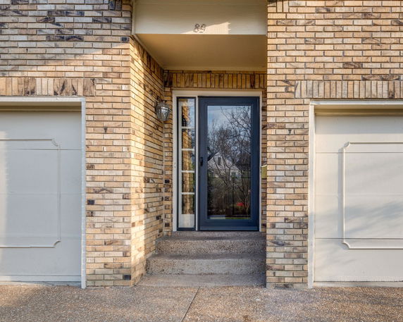Front view of a house with double garage doors and a central entryway.