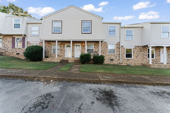 Front view of a two-story townhouse with brick and siding exterior.