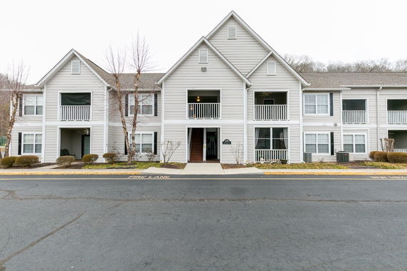 Front view of a multi-story residential building with balconies and a central entrance.