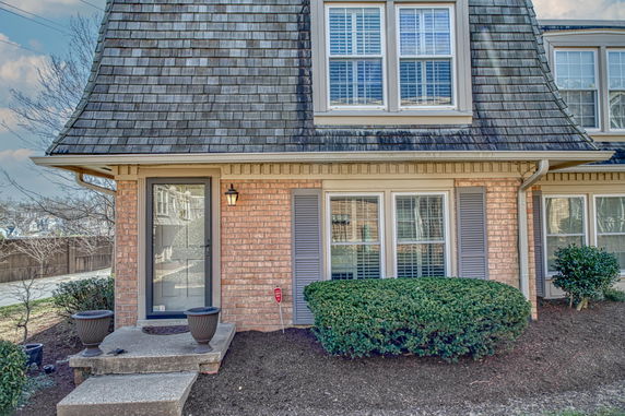 Front view of a house with a sloped roof and brick exterior.