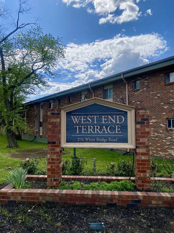 Front view of a brick residential building with a sign reading 'West End Terrace'.