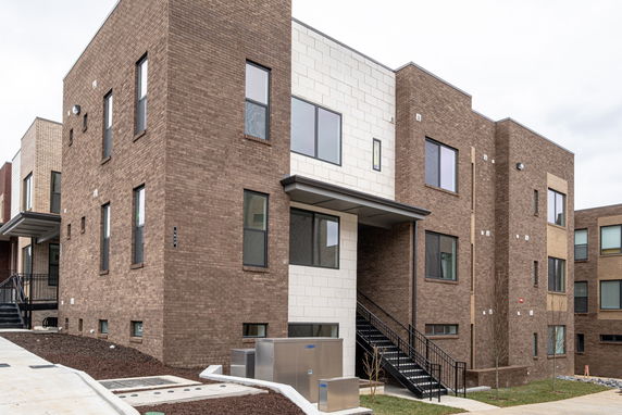 Front view of a modern multi-story brick apartment building.