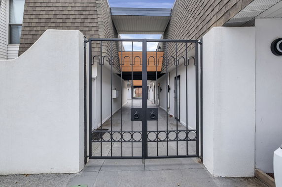 Front view of a building with a gated entrance and shingle siding.