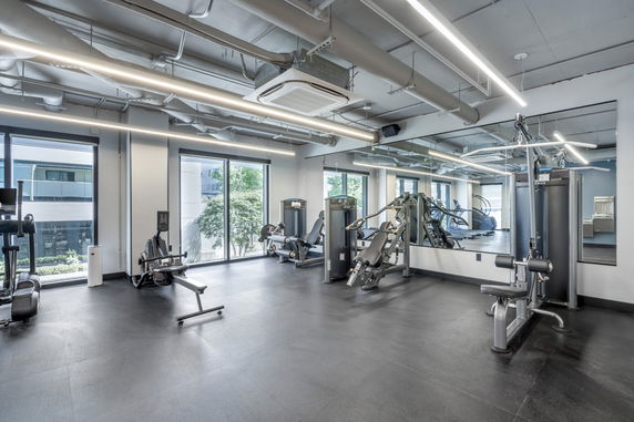 Indoor gym area with exercise equipment and large mirrors.